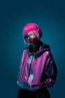 Giovane donna asiatica con elegante taglio di capelli rosa e scintillante giacca d'argento in piedi e ascoltare musica — Foto stock