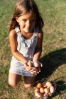 Kleines Mädchen mit Eierkorb auf Bauernhof und Blick in die Kamera — Stockfoto