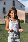 Little girl holding eggs in farm and looking at camera — Stock Photo