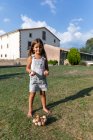 Kleines Mädchen hält Eier in Bauernhof und blickt in Kamera — Stockfoto