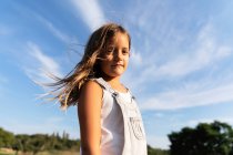 Jeune fille posant dans la lumière du soleil regardant la caméra — Photo de stock
