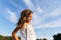 Junges Mädchen posiert im Sonnenlicht und schaut weg — Stockfoto