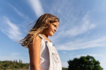 Junges Mädchen posiert im Sonnenlicht und schaut weg — Stockfoto