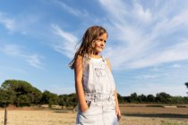 Young girl posing in sunlight looking away — Stock Photo