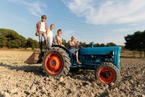 Ältere Frau fährt Traktor bei Feldarbeiten am sonnigen Tag auf Bauernhof — Stockfoto