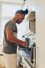 Afrikanisch-amerikanischer Flechtmann steht mit Pfanne und Schulterblatt in der Küche — Stockfoto