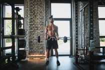 Schwarzer Mann trainiert mit Langhantel im Fitnessstudio — Stockfoto