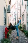Молода струнка випадкова жінка тягнеться на вулиці старого міста під час витончених танців — стокове фото
