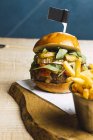 Saftige leckere Burger und Bratkartoffeln auf Holzbrett — Stockfoto