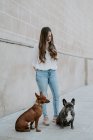 Trendige moderne Frau mit Bulldogge und Hund steht auf dem Bürgersteig und lächelt — Stockfoto
