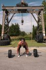 Young guy training with barbell in outdoor gym — Fotografia de Stock