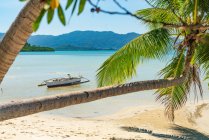 Barca ormeggiata alla spiaggia paradiso tropicale — Foto stock