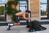 Black guy pulling weights in outdoor gym — Stock Photo