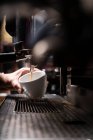 Растениеводство рук человека, делающего кофе с помощью автоматического профессионального оборудования в кафе — стоковое фото