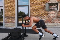 Black guy pulling weights in outdoor gym — Fotografia de Stock