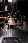 Обрізати руки людини, роблячи каву автоматичним професійним обладнанням в кафе — стокове фото