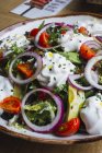 Gemüsesalat mit Zwiebelgemüse und Sahnesoße auf Teller serviert — Stockfoto
