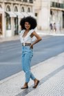 Щаслива етнічна жінка в модному вбранні і дивиться на камеру в літній день — стокове фото
