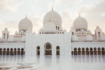 Moschea bianca con cupole e minareti sotto il cielo blu brillante, Dubai — Foto stock