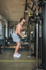 Kerl mit Trainingsgerät im Fitnessstudio, Seitenansicht — Stockfoto