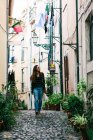 Молодая брюнетка ходит по мощеной улице старого города — стоковое фото
