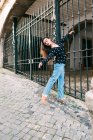 Young slim casual woman stretching while dancing on street of old city — Stock Photo