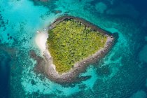 Luftaufnahme von Booten neben einer kleinen grünen tropischen Insel inmitten des azurblauen Wassers des Ozeans — Stockfoto
