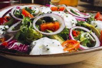 Salada de legumes com verduras de cebola e molho de creme servido no prato — Fotografia de Stock