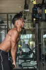 Schwarzer Typ mit Trainingsgerät im Fitnessstudio, Seitenansicht — Stockfoto