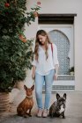 Moderne Frau mit Bulldogge und Hund steht auf Gehweg — Stockfoto