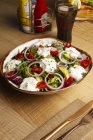 Vegetable salad with onion greens and cream sauce served on plate on wooden table — Stock Photo