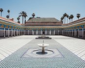Pátio com piso em azulejo colorido e fontes cercadas com galeria coberta e pilares em estilo oriental, Marrocos — Fotografia de Stock