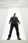 Впевнений афроамериканець людина в чорному одязі з плетеними волосся стоячи ізольований на білому фоні — стокове фото