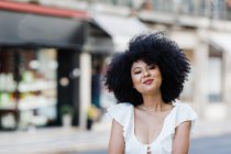 Молодая афроамериканка улыбается в камеру на улице — стоковое фото
