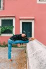Junge schlanke, lässige Frau dehnt sich auf der Straße der Altstadt, während sie anmutig tanzt — Stockfoto