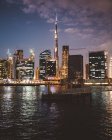 Набережная против светящихся небоскребов Дубая ночью — стоковое фото