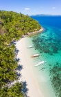 Вид з повітря на мальовничий океанський берег з пальмовим гаєм і причаленими човнами в сонячний день — стокове фото