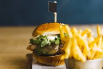 Saftige leckere Burger und Bratkartoffeln auf Holztisch — Stockfoto
