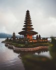 Невеликий комплекс молитовної пагоди з зеленим садом навколо вбудованих у воду на березі проти туману, Балі — стокове фото