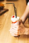 Crème glacée blanche en cône de papier dans les mains — Photo de stock