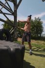 Muskulös schwarz kerl hämmern reifen im outdoor fitnessstudio — Stockfoto