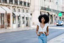 Ethnische Frau im trendigen Outfit und Blick in die Kamera an einem Sommertag — Stockfoto