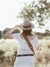 Mulher em roupas brancas e chapéu em pé ao ar livre à luz do dia — Fotografia de Stock