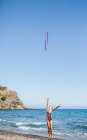 Грациозный акробат выступает с обручем на пляже — стоковое фото