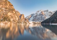 Impresionante paisaje con reflejo mágico de montañas rocosas en aguas cristalinas del lago en un día soleado brillante - foto de stock