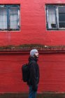 Bearded man looking away while standing in front of red building in faroe island — Stock Photo