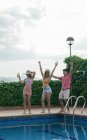 Grupo de amigos com uma festa na piscina enquanto dançam, riem e bebem coquetéis — Fotografia de Stock