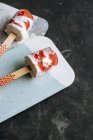 Pastèque et crème glacée sur bâtonnets sur planches sur fond sombre — Photo de stock