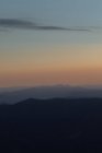 Pintoresca vista de majestuosa puesta de sol brillante por encima de oscuros acantilados - foto de stock