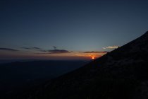 Живописный вид величественного яркого заката над темными пиковыми скалами — стоковое фото
